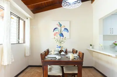 a dining room with a table and chairs and a kitchen at Cata bed & breakfast 2026 in San José
