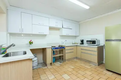 a kitchen with white cabinets and a stainless steel refrigerator at Cata bed & breakfast 2026 in San José