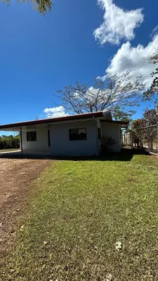 a small white house with a grass yard at Casa Tano in San Isidro
