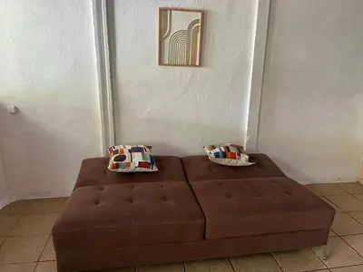 a brown couch sitting in a room with two pillows at Complete house for 6 people in San Isidro