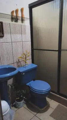 a bathroom with a blue toilet and a sink at Complete house for 6 people in San Isidro