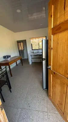 a kitchen with a table and a refrigerator in a room at Casa Tano in Delicias
