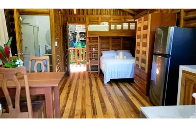 a bedroom with a bed and a refrigerator in a room at Cabañas Samara Buenavista in Sámara