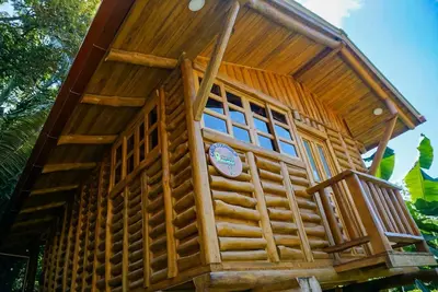 a tree house with a porch and a sign on it at Cabañas Samara Buenavista in Sámara