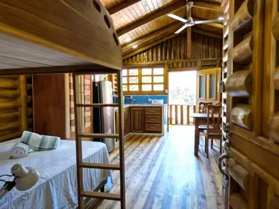 a bedroom with a bunk bed and a kitchen at Cabañas Samara Buenavista in Sámara