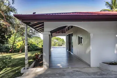 an entrance to a white house with an archway at Sunset Villa Uvita - an oceanview 4 bedroom home - no 4x4 needed in Uvita