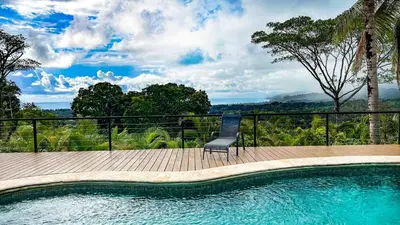 a chair sitting next to a swimming pool at Sunset Villa Uvita - an oceanview 4 bedroom home - no 4x4 needed in Uvita