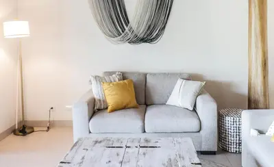 a living room with a gray couch with yellow pillows at Sunset Villa Uvita - an oceanview 4 bedroom home - no 4x4 needed in Uvita