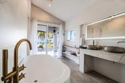 a white bathroom with a tub and a sink at Sunset Villa Uvita - an oceanview 4 bedroom home - no 4x4 needed in Uvita