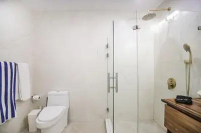 a bathroom with a toilet and a glass shower at Sunset Villa Uvita - an oceanview 4 bedroom home - no 4x4 needed in Uvita