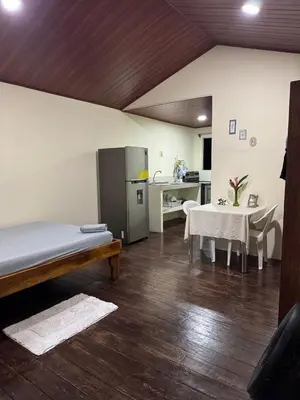 a room with a kitchen and a table and a refrigerator at Casa lapas in San Isidro