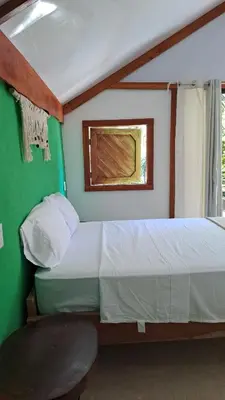 a small bedroom with a bed and a window at Casa AllíS in Cóbano