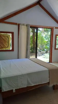 a large bed in a room with a large window at Casa AllíS in Cóbano