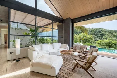 a living room with a white couch and chairs at Steady As We Go in Nosara