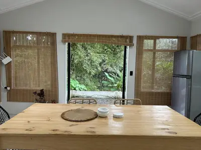 a kitchen with a wooden table and a refrigerator at Cabin Retreat - Nature & Privacy - La Fortuna in Fortuna