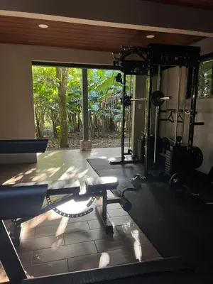 a room with a gym with a large window at Quiet Miravalles Volcano Farm House with Pool in Bagaces