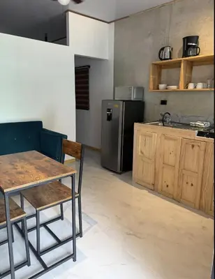 a kitchen with a table and a stainless steel refrigerator at Santa Teresa Apartments CR in Santa Teresa