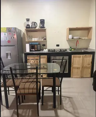 a kitchen with a glass table and chairs and a refrigerator at Santa Teresa Apartments CR in Santa Teresa