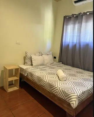 a bedroom with a bed with a black curtain at Santa Teresa Apartments CR in Santa Teresa