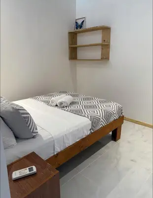 a bedroom with a bed and a table with a remote control at Santa Teresa Apartments CR in Santa Teresa