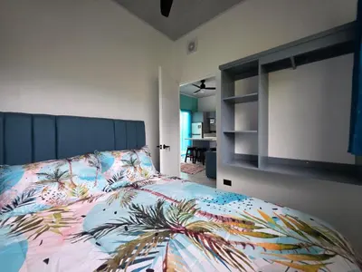 a bedroom with a bed with a colorful comforter at The Palm at Life's a Beach in Uvita
