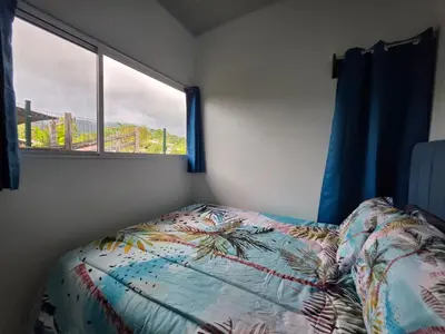 a bedroom with a bed and a window at The Palm at Life's a Beach in Uvita