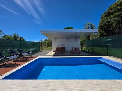 a swimming pool in a backyard with a house at The Palm at Life's a Beach in Uvita