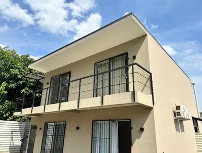 a white house with a balcony on top of it at Josuary in Brasilito