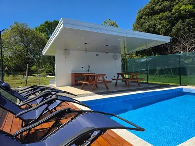 a house with a swimming pool and a table at Sunshine at Life's a Beach in Uvita