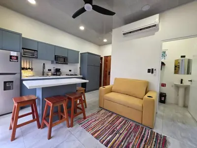 a kitchen with a couch and a table and chairs at Sunshine at Life's a Beach in Uvita