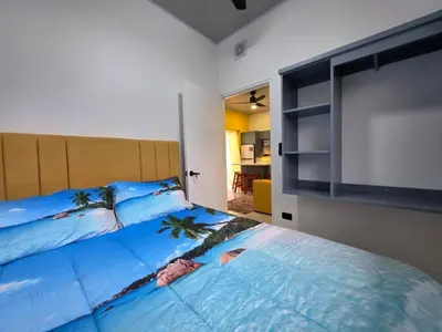a bedroom with a large bed with a flat screen tv at Sunshine at Life's a Beach in Uvita