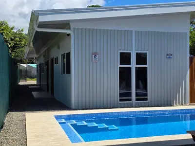 a building with a swimming pool in front of it at Sunshine at Life's a Beach in Uvita