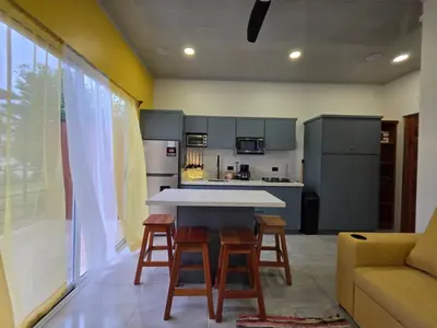 a kitchen with a table and chairs and a couch at Sunshine at Life's a Beach in Uvita