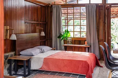 a bedroom with a bed and a table and a window at Casa Cúrcuma in Turrialba