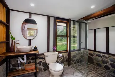 a bathroom with a toilet and a sink at Casa Cúrcuma in Turrialba