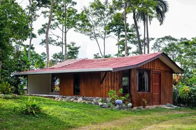 a small wooden house with a red roof at Casa Cúrcuma in Turrialba