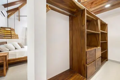 a bedroom with a bed and a wooden closet at Casa Aves in Santa Cruz