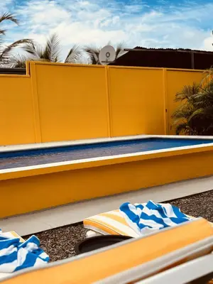 a swimming pool with a yellow wall next to it at Casitas Amarillas in Uvita