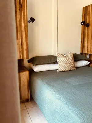 a bedroom with a bed with two pillows on it at Casitas Amarillas in Uvita