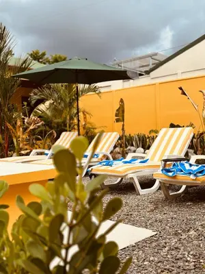 a group of lounge chairs and an umbrella at Casitas Amarillas in Uvita