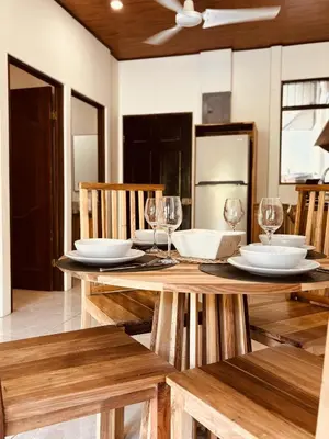 a wooden table with glasses and plates on it at Casitas Amarillas in Uvita