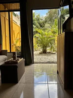 a living room with a large glass door to a garden at Casitas Amarillas in Uvita