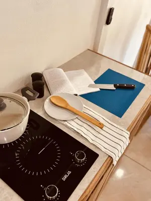 a kitchen counter with a stove and a book on it at Casitas Amarillas in Uvita