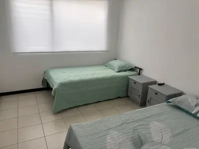 a bedroom with two beds and a window at Casa Brisamar - House with Private Pool in Herradura