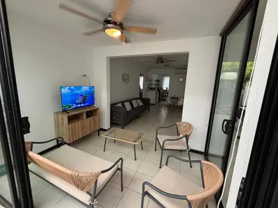 a living room with chairs and a flat screen tv at Casa Brisamar - House with Private Pool in Herradura