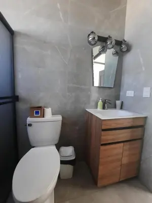 a bathroom with a white toilet and a sink at Tierra de Gosén in Santa Cruz