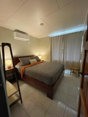 a bedroom with a bed and a desk and a window at Casa Luz Volcano View La Fortuna in Fortuna