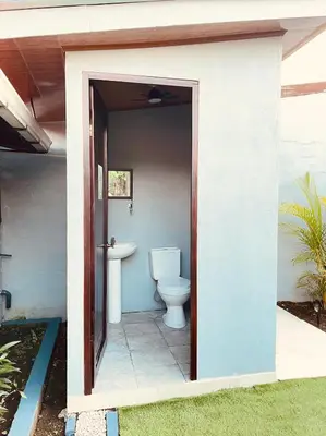 a bathroom with a toilet inside of a house at Casa Luz Volcano View La Fortuna in Fortuna