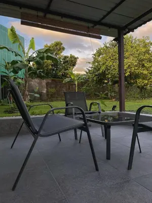 two chairs and a glass table on a patio at Casa Luz Volcano View La Fortuna in Fortuna