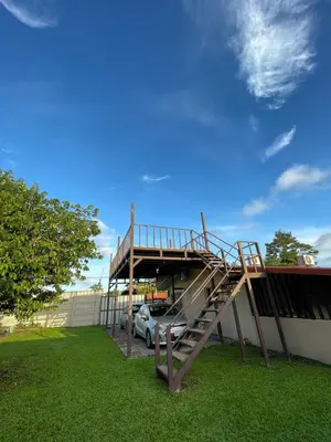 a metal staircase in front of a building with a car at Casa Luz Volcano View La Fortuna in Fortuna